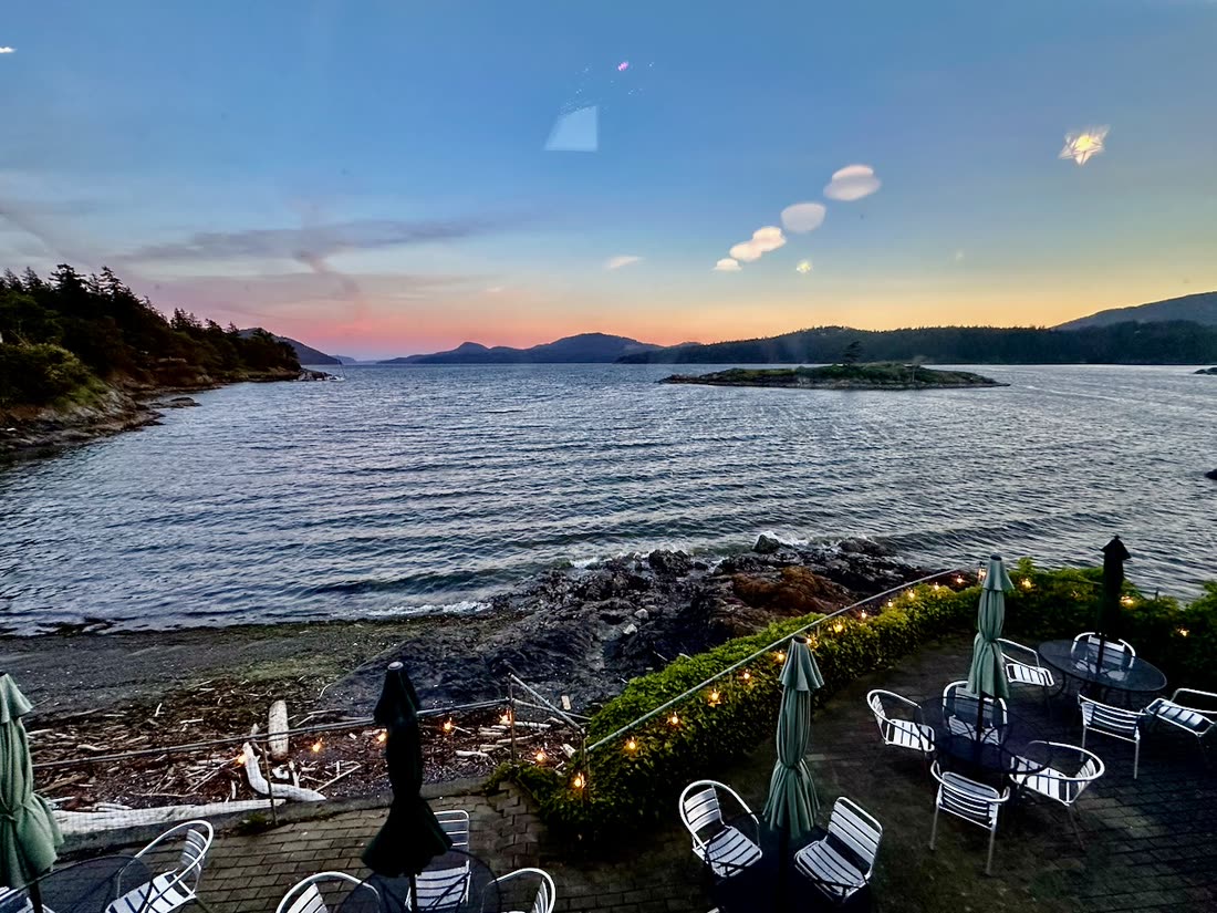A waterfront terrace at dusk with the islands beyond